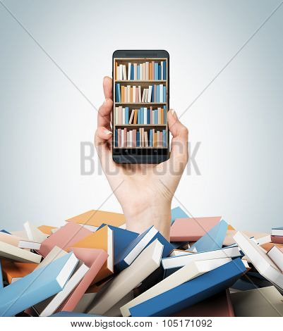 A Hand Holds A Smartphone With A Book Shelf On The Screen. A Heap Of Colourful Books. A Concept Of E