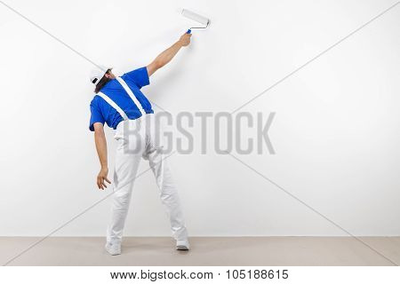 Painter With Paintroller On White Wall