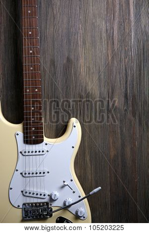 Electric guitar on wooden background, close up