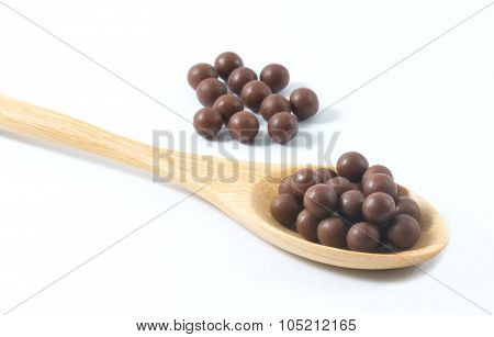 Wooden Spoon Full Of Herbal Cough Lozenges On White Background