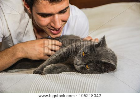 Handsome Young Man Cuddling his Gray Cat Pet