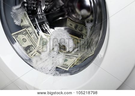 Laundering of money in washing machine, close up