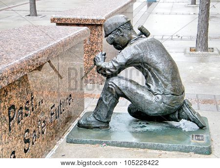 TORONTO, CANADA - MARCH 22, 2010: The Anonymity of prevention bronze statue showing a worker working with a chisel and hammer with safety goggles at WSIB  Simcoe Park Workers Monument on March 22, 2010 in Toronto, Canada