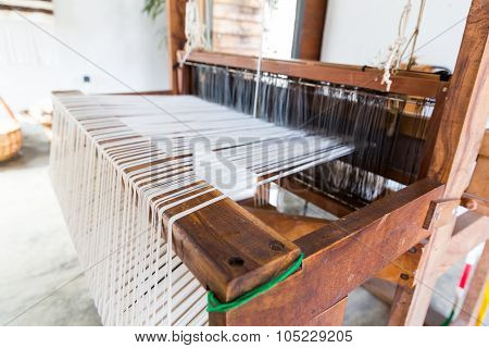 Old shuttleless loom with black and white wools working in the room 