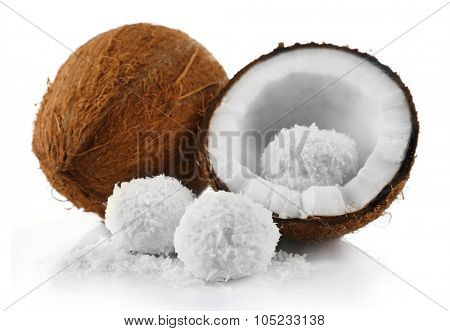 Candies in coconut flakes and fresh coconut isolated on white