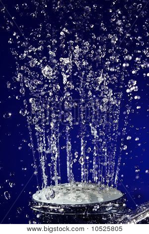 Mano doccia doccia con movimento fermato acqua scende sul profondo blu
