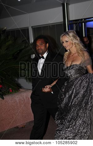 CANNES, FRANCE - MAY 17: Former footballer Christian Karembeu and model Adriana Karembeu depart 'Biutiful' Premiere  during the 63rd  Cannes  Festival on May 17, 2010 in Cannes, France
