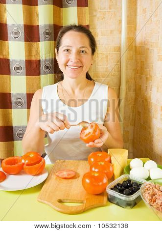 Reife Frau macht Gefüllte Tomaten
