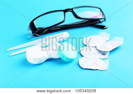 Contact Lenses In Container With Solution On Blue Background