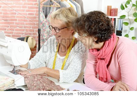 Two happy women sewing in their workshop