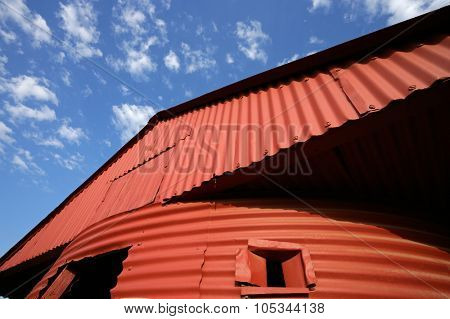 Red barn against a blue sky with clouds 
