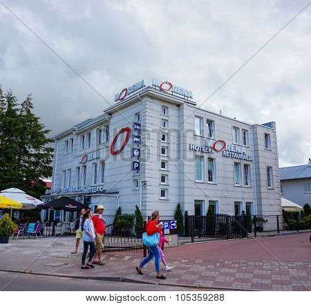 USTRONIE MORSKIE POLAND - JULY 20 2015: People passing the Morena Hotel building in the town center