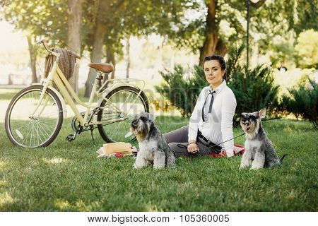 Young Woman With Dogs And Bicycle Having Picnic In The Park