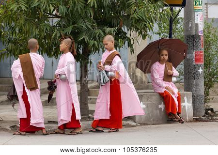 MANDALAY,MYANMAR,JANUARY 17, 2015: A group of young Buddhist nuns is walking in the streets of Mandalay, Myanmar (Burma).