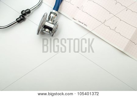 Blue stethoscope and cardiogram lie on a table