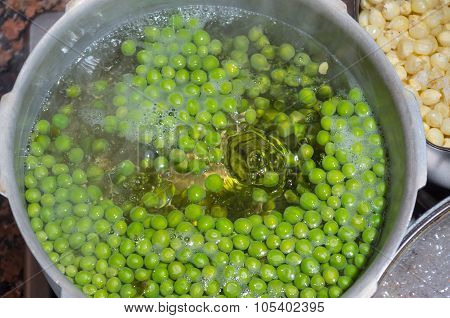 Green peas cooking in silver colored metal pot. fanesca preparation concept