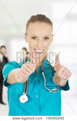 Beautiful smiling woman doctor with thumbs up.