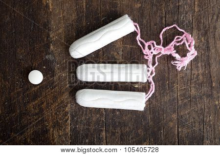 Clean white tampons lying on wooden surface