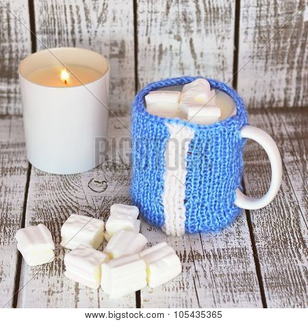 Mug with milk and marsmallow on the white table