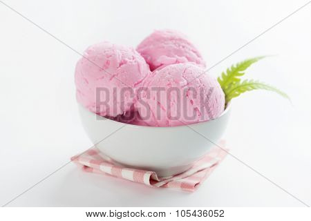Scoop pink ice cream in bowl with table cloth on white background.