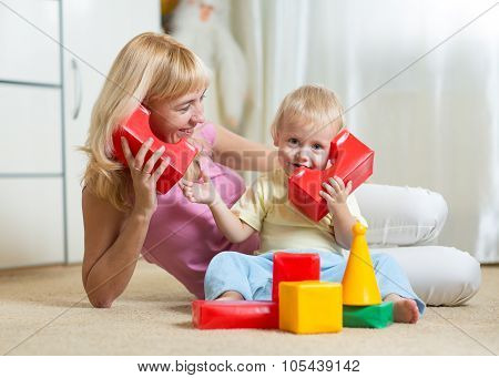 cute mother and kid boy playing together indoor