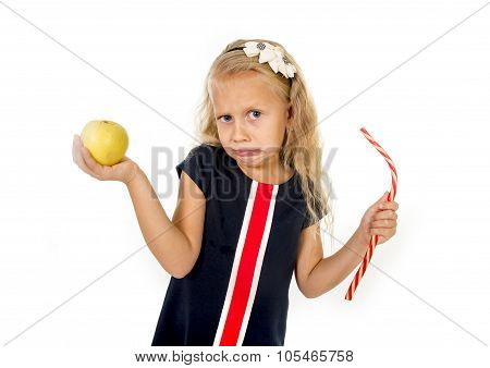 Little Pretty Female Child Choosing Dessert Holding Unhealthy But Tasty Red Candy Licorice And Apple