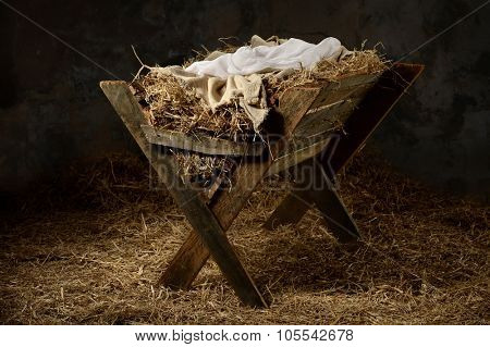 Manger with hay and swaddling clothes in old stable