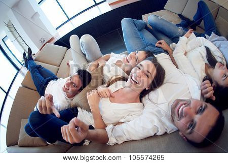 portrait of happy young group of friends get releax and have fun at modern home interior, top view