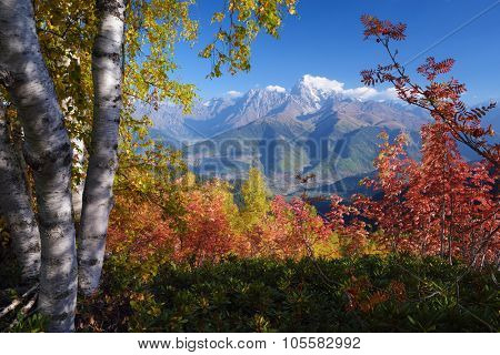 Autumn landscape. Sunny day in the mountains. View of the mountain Ushba with Mount Mheer. Main Caucasian ridge. Zemo Svaneti, Georgia 