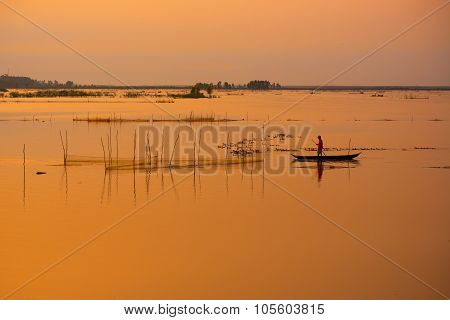 Fisher on boat in water season in sunrise in Dong Thap, Vietnam