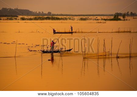 Fisher on boat in water season in sunrise in Dong Thap, Vietnam