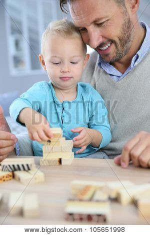 Daddy with 2-year-old boy playing with wooden blocks