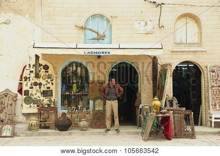 Man stands in at the souvenir shop entrance in El Djem, Tunisia.