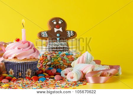 Twisted Marshmallow And Cupcakes  On Brigth Yellow Background And Gingerbread Rman