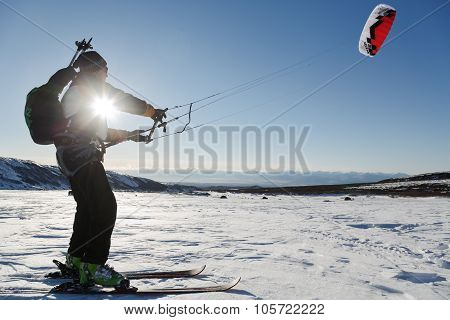 Snowkiting (kiteboarding) - Sportsman Glides On Skis At Sunset