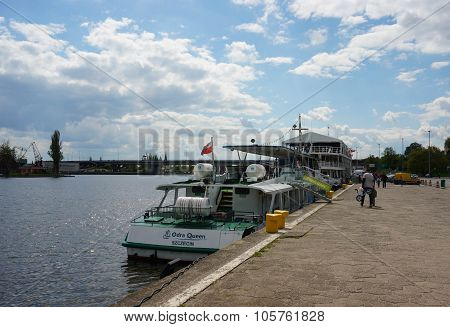 SZCZECIN POLAND - MAY 02 2015: People passing a boat by the Odra river