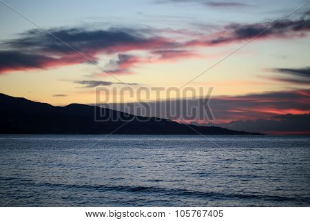 Mountain Silhouette In Sea After Sunset