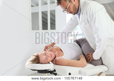Physiotherapist stretching woman's leg