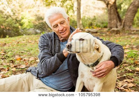 Senior man with his dog in park on an autumns day