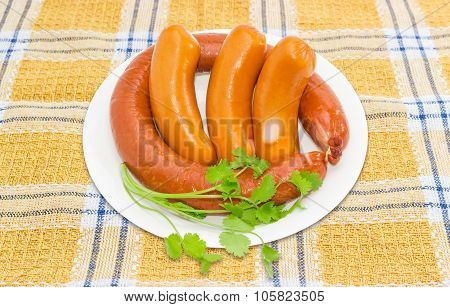 Sausages With Branch Of Coriander On A White Dish