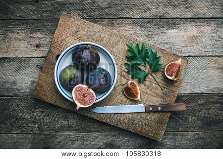Figs And Knife On Chopping Board And Wooden Table