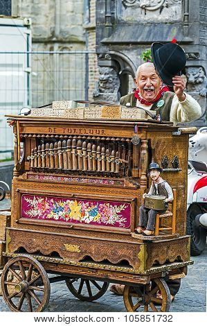 Old Man With Traditional Belgian Hurdy-gurdy, On A Street In Bruges, Belgium