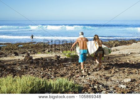 Surfers Surf On The Waves