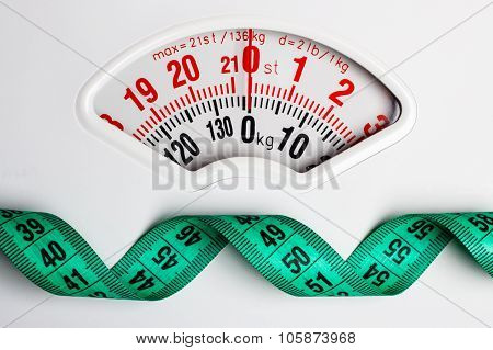 Green Measuring Tape On Weight Scale. Dieting