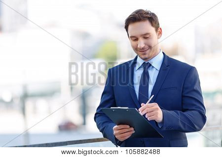 Gentleman in suit using a clipboard.