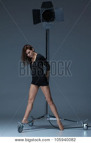 The beautiful ballerina posing on dack blue background
