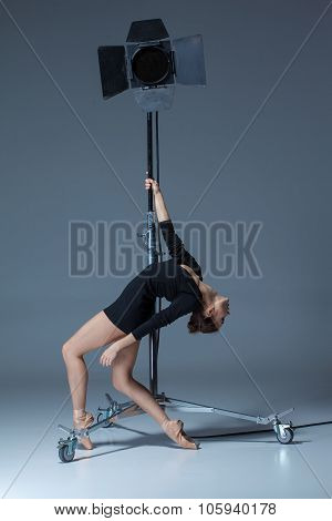 The beautiful ballerina posing on dack blue background