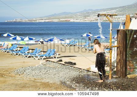 Girl-surfer Wash In The Shower. Playa De Las Americas, Tenerife, Canary Islands, Spain