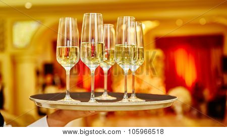 Waiter serving champagne on a tray