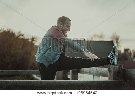 Sport Man Stretching Aoutdoors Doing Exercises Evening At Sunset. Fitness Concepts.